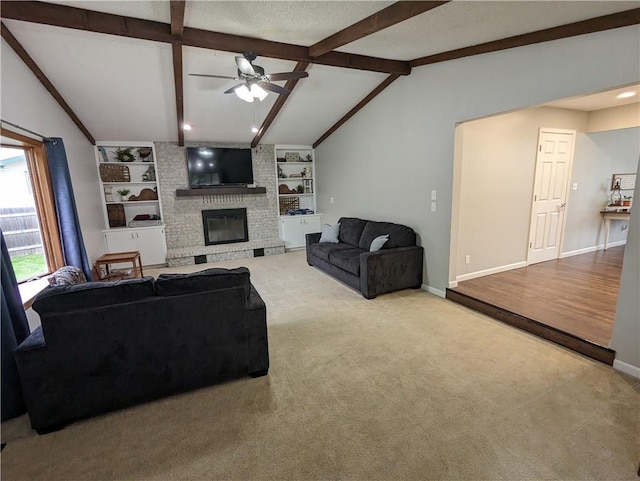 carpeted living room featuring built in shelves, ceiling fan, a fireplace, and vaulted ceiling with beams