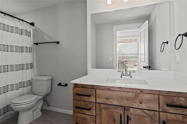 bathroom with toilet, vanity, and tile patterned flooring