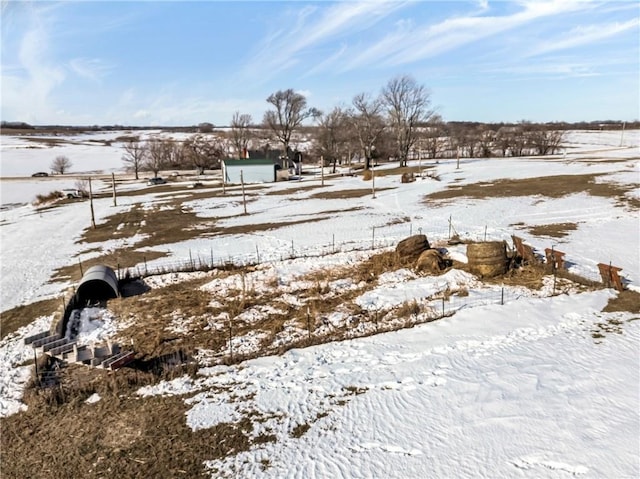 yard covered in snow featuring a rural view