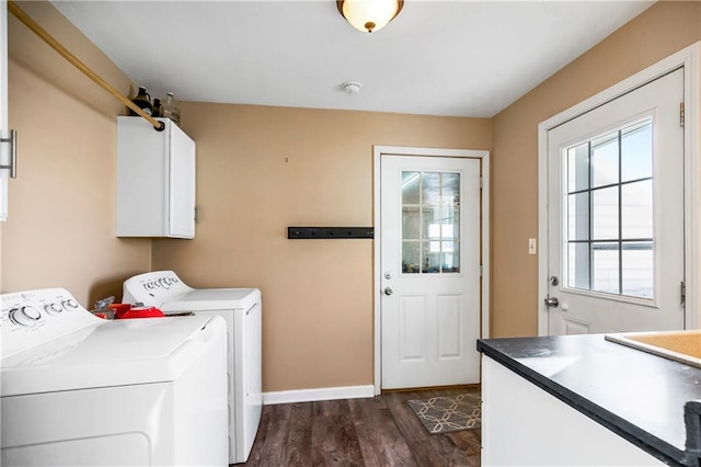 washroom with washing machine and clothes dryer, dark wood-type flooring, and cabinets