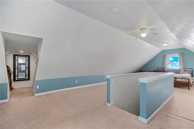 additional living space featuring ceiling fan, light colored carpet, and lofted ceiling