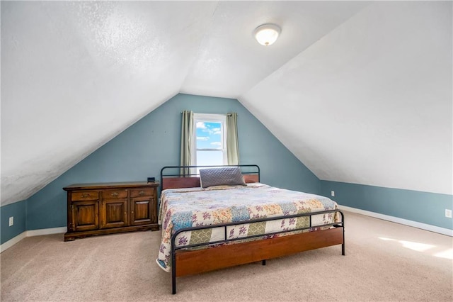 bedroom featuring light colored carpet and vaulted ceiling