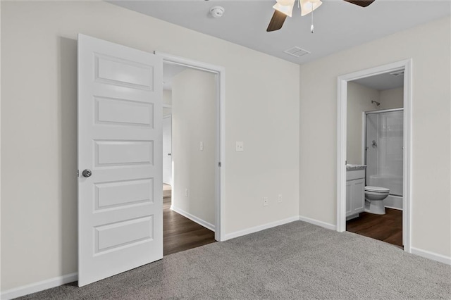 unfurnished bedroom featuring ceiling fan, connected bathroom, and dark colored carpet