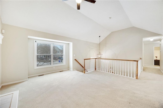 spare room featuring light carpet, ceiling fan, and lofted ceiling