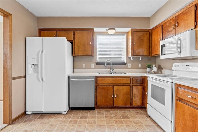 kitchen with sink, white appliances, and a healthy amount of sunlight