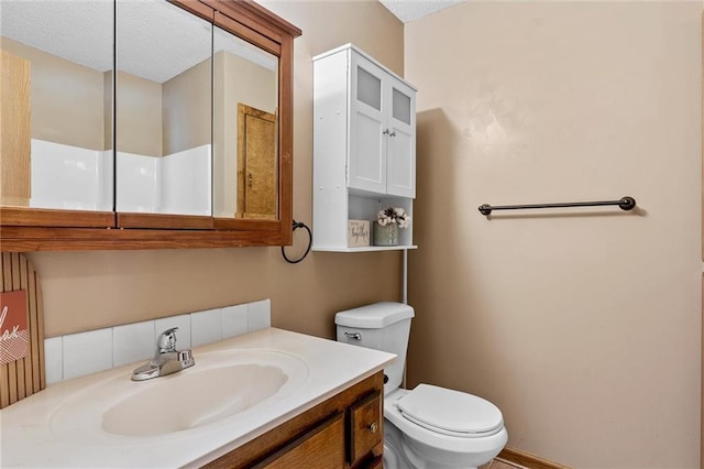 bathroom with toilet, vanity, and a textured ceiling