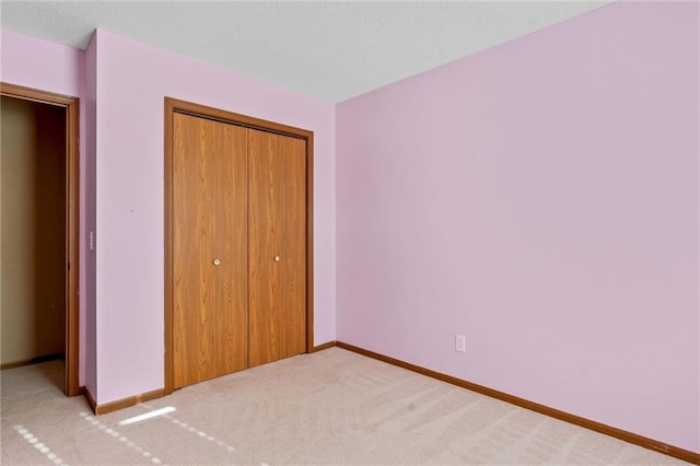 unfurnished bedroom featuring light colored carpet and a closet