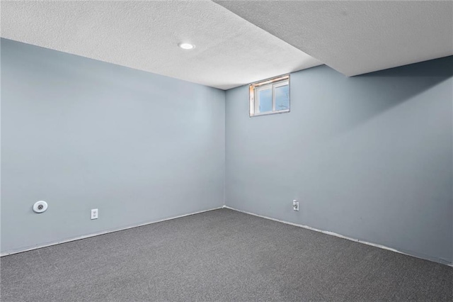 basement featuring carpet flooring and a textured ceiling