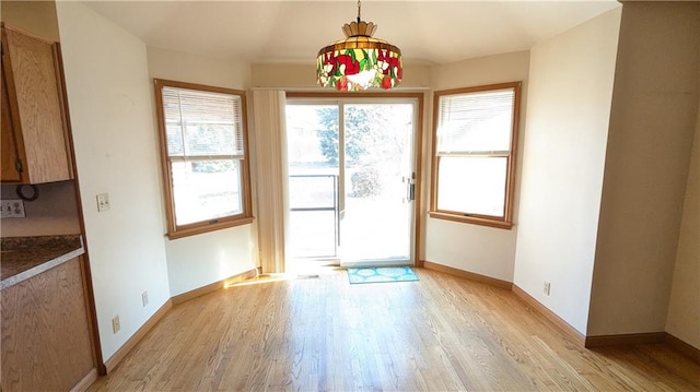 doorway to outside featuring light hardwood / wood-style floors and an inviting chandelier