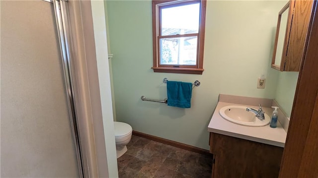 bathroom with toilet, a shower with door, a healthy amount of sunlight, and vanity