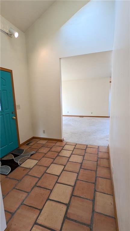 1205 Wentley Dr, Hiawatha, KS 66434 - entrance foyer with brick floor, a high ceiling, and baseboards