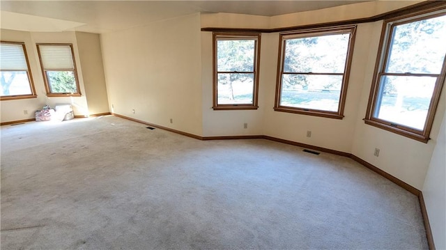 1205 Wentley Dr, Hiawatha, KS 66434 - unfurnished room featuring baseboards, light carpet, and a healthy amount of sunlight