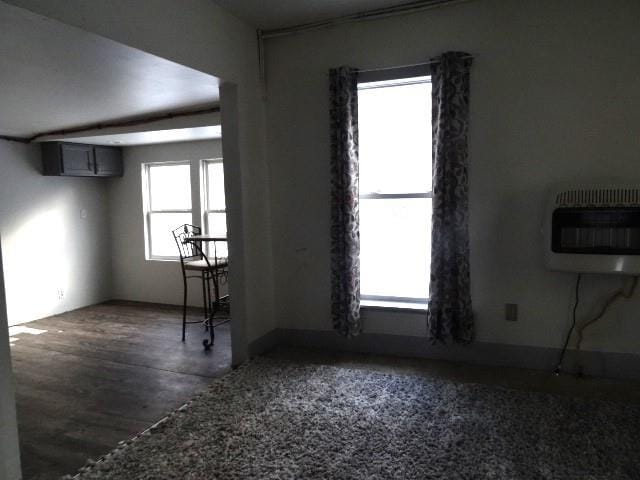 empty room with a healthy amount of sunlight, a wall mounted AC, and heating unit