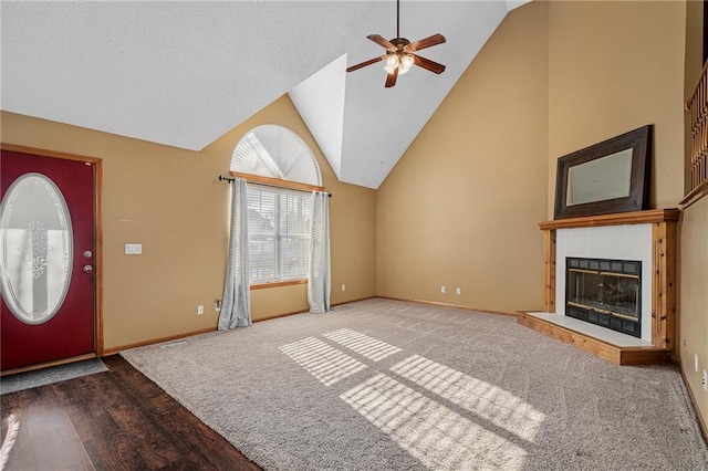 unfurnished living room with ceiling fan, hardwood / wood-style floors, a tile fireplace, and lofted ceiling