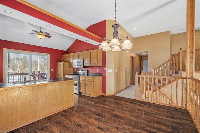 kitchen featuring pendant lighting, dark wood-type flooring, stainless steel appliances, sink, and vaulted ceiling