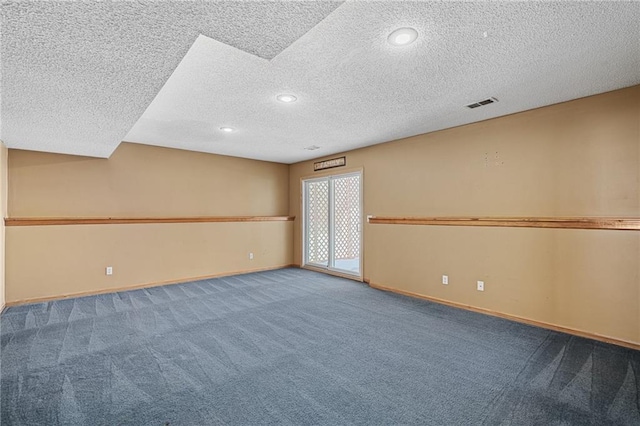 carpeted spare room featuring a textured ceiling