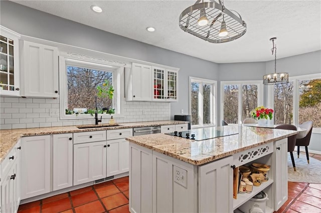 kitchen featuring tasteful backsplash, white cabinetry, and decorative light fixtures