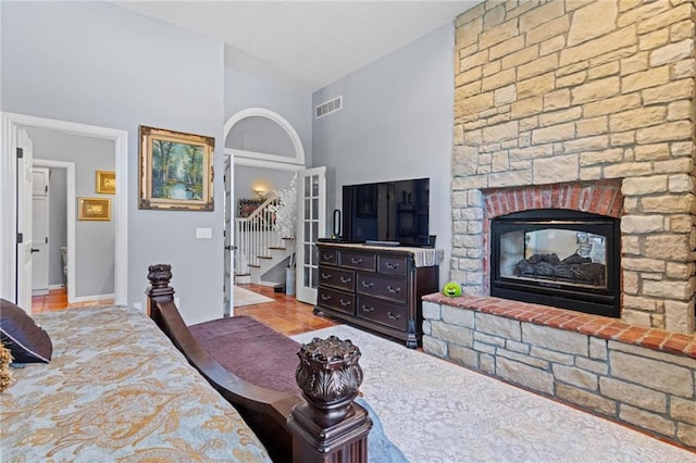 bedroom featuring a stone fireplace and light tile patterned flooring