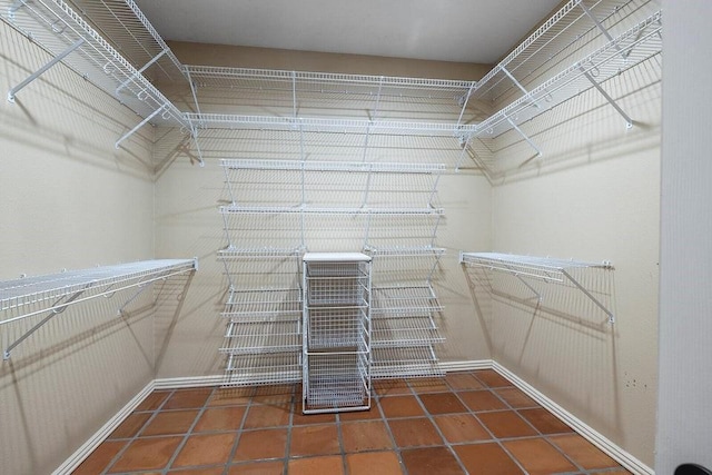 walk in closet featuring dark tile patterned floors