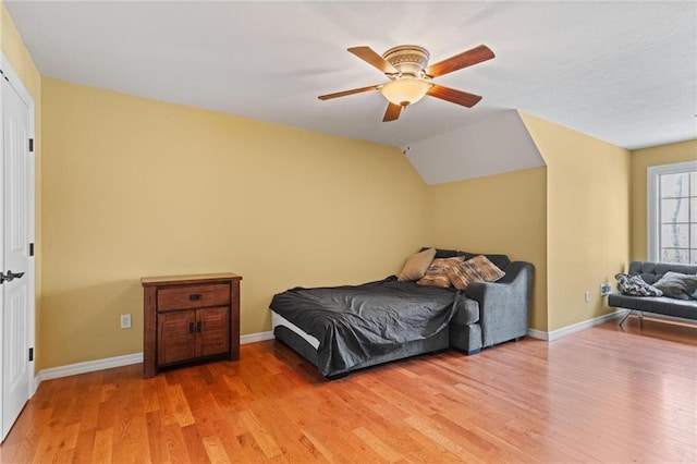 bedroom featuring ceiling fan, wood-type flooring, and vaulted ceiling