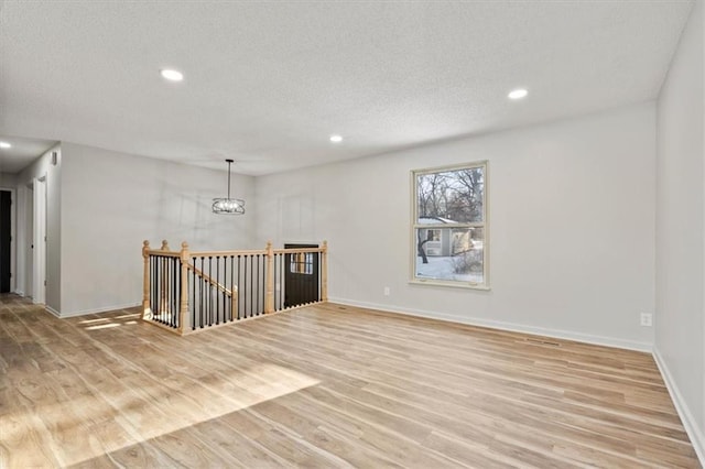 empty room featuring light hardwood / wood-style floors and an inviting chandelier