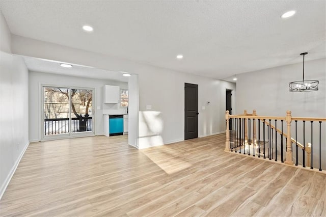 empty room featuring light hardwood / wood-style flooring and a notable chandelier