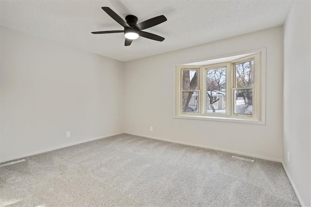 empty room featuring a textured ceiling, ceiling fan, and carpet flooring