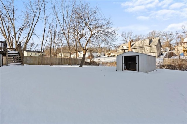 yard covered in snow featuring a storage shed