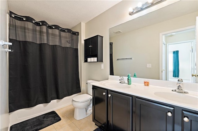 full bathroom with vanity, tile patterned floors, toilet, a textured ceiling, and shower / tub combo