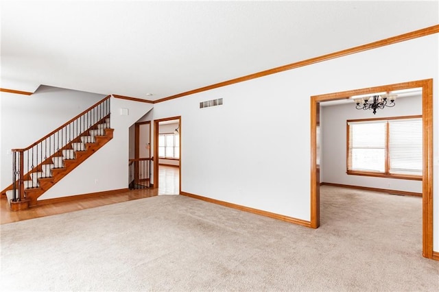 unfurnished living room featuring baseboards, visible vents, carpet flooring, and stairs