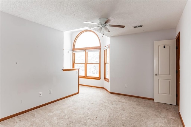 spare room featuring a ceiling fan, baseboards, visible vents, and carpet flooring