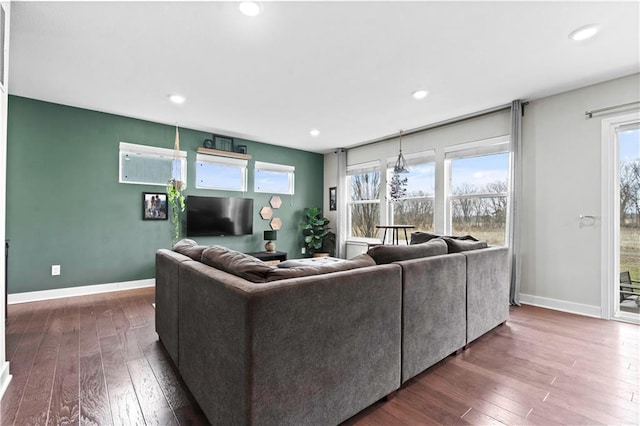 living area featuring baseboards, dark wood finished floors, a wealth of natural light, and recessed lighting