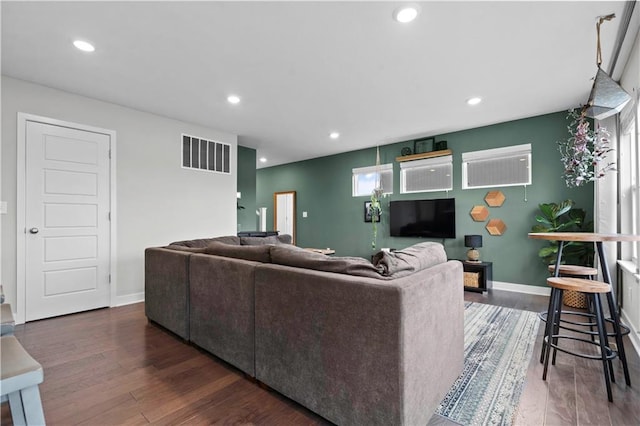 living area with recessed lighting, visible vents, dark wood finished floors, and baseboards