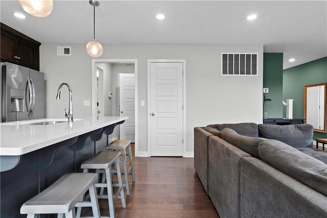 kitchen with hanging light fixtures, stainless steel fridge, visible vents, and light countertops