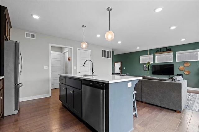 kitchen with a center island with sink, visible vents, appliances with stainless steel finishes, light countertops, and a sink