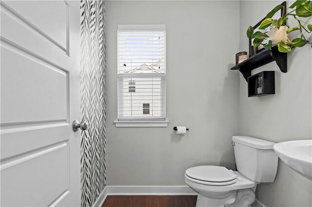 bathroom featuring toilet, baseboards, and wood finished floors