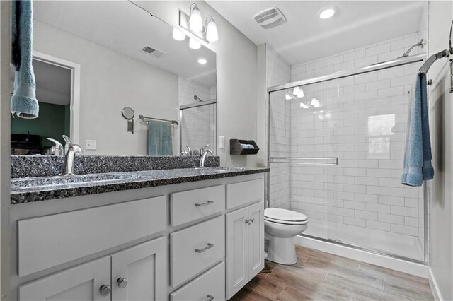 full bath with double vanity, a sink, visible vents, and wood tiled floor