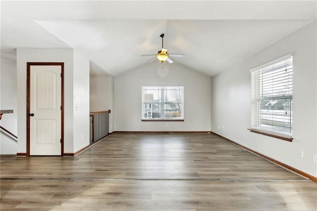 unfurnished living room with ceiling fan, hardwood / wood-style floors, and vaulted ceiling