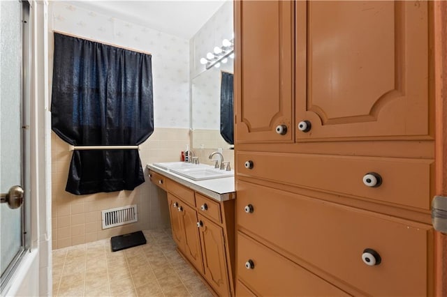 bathroom with tile patterned flooring, vanity, and tile walls