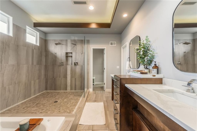 bathroom with vanity and a tile shower