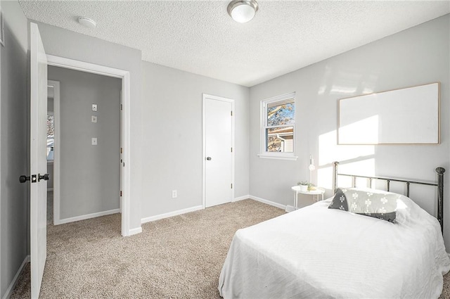 bedroom featuring a textured ceiling and light carpet