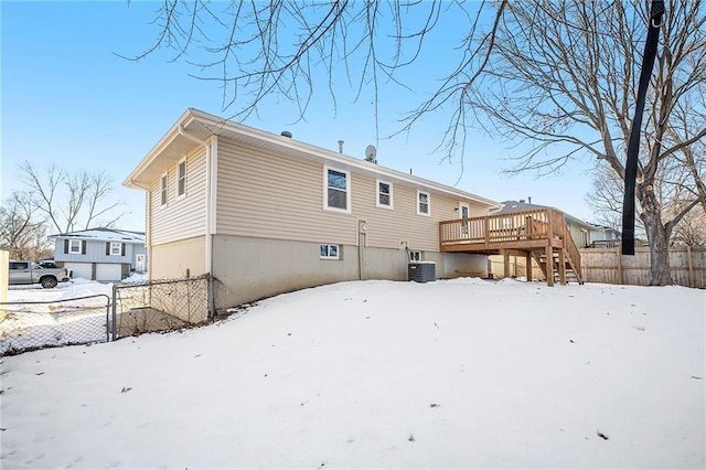 snow covered property featuring central AC and a wooden deck