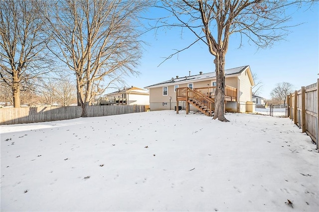 yard layered in snow with a deck