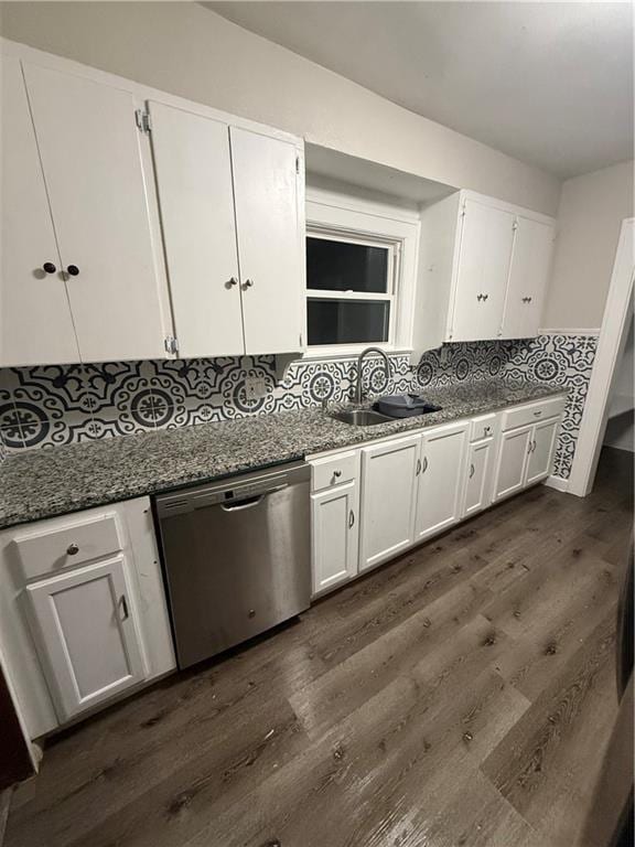 kitchen featuring dark hardwood / wood-style flooring, sink, dark stone countertops, dishwasher, and white cabinetry