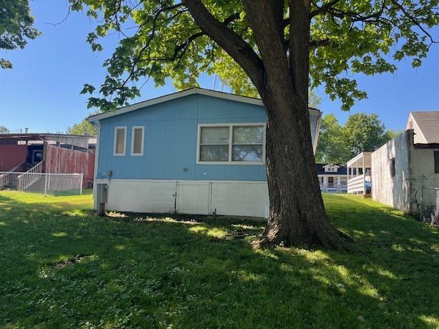 view of side of home with a yard