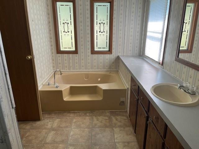 bathroom with tile patterned floors, a bathtub, and vanity