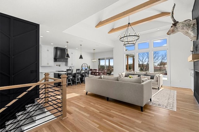 living room featuring light wood-type flooring, beamed ceiling, and a notable chandelier