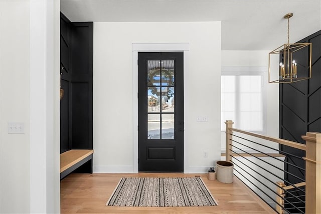 mudroom with an inviting chandelier and hardwood / wood-style floors