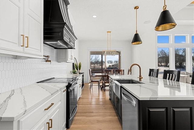 kitchen with pendant lighting, dishwasher, a center island with sink, and electric range oven