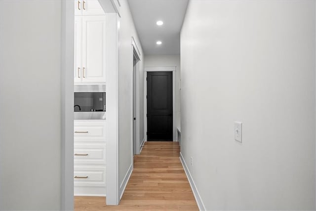 hallway with light hardwood / wood-style floors